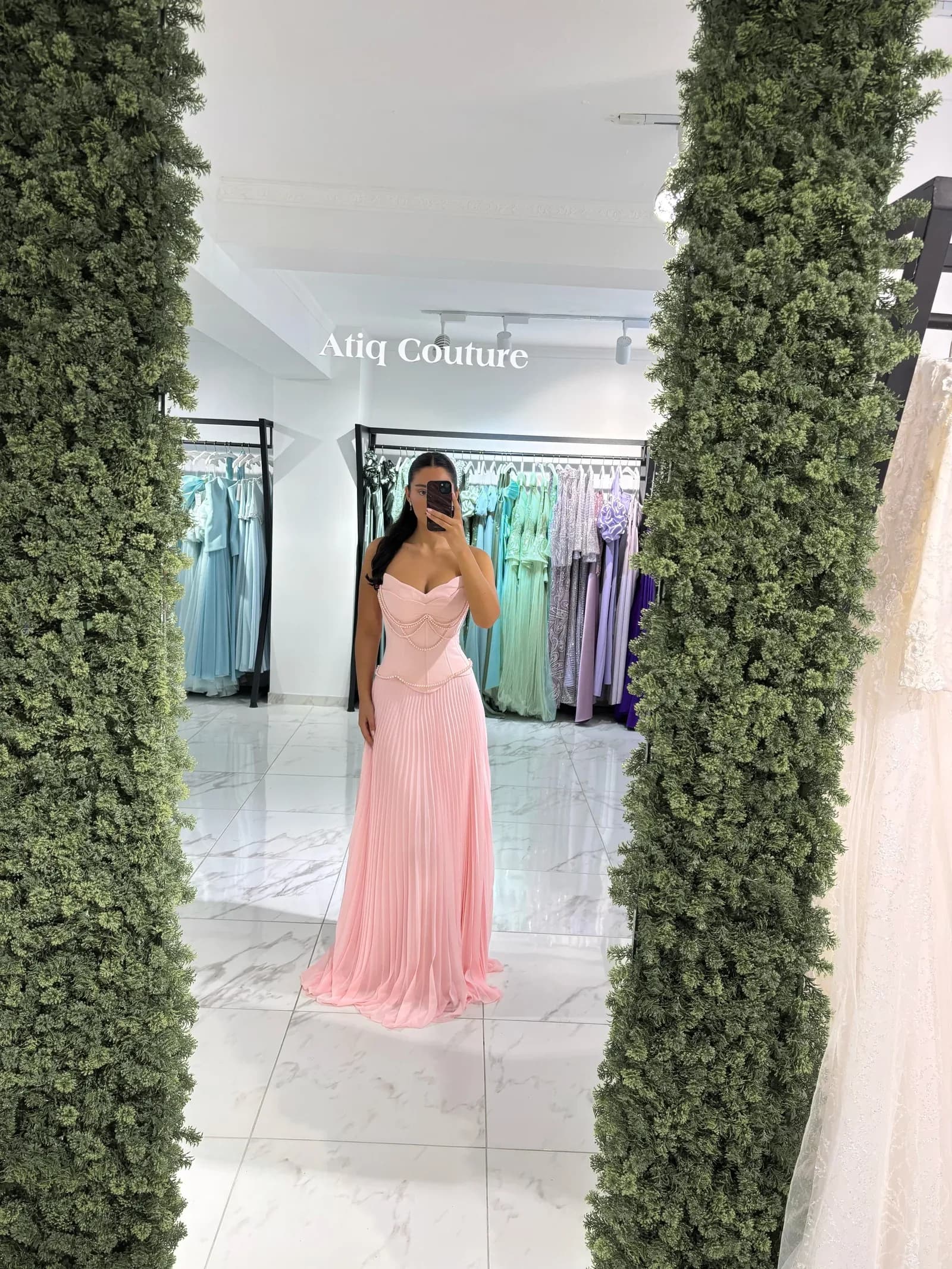 Rosafarbenes Abendkleid vor der Blumenwand